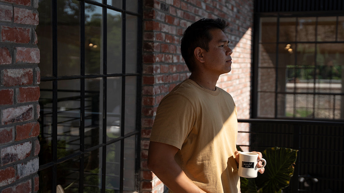 Man standing outside holding mug of coffee