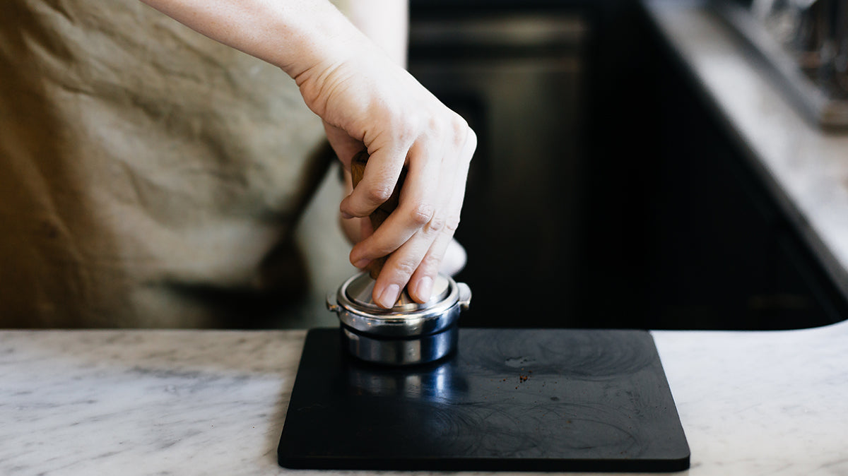 barista making tamping blonde espresso