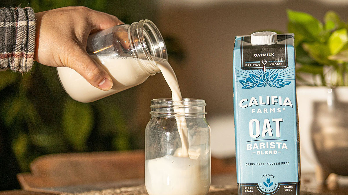 barista pouring oatmilk coffee
