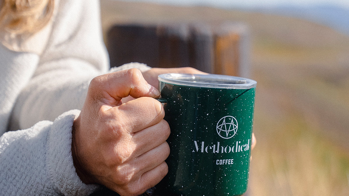 Woman holding a cup of coffee outside