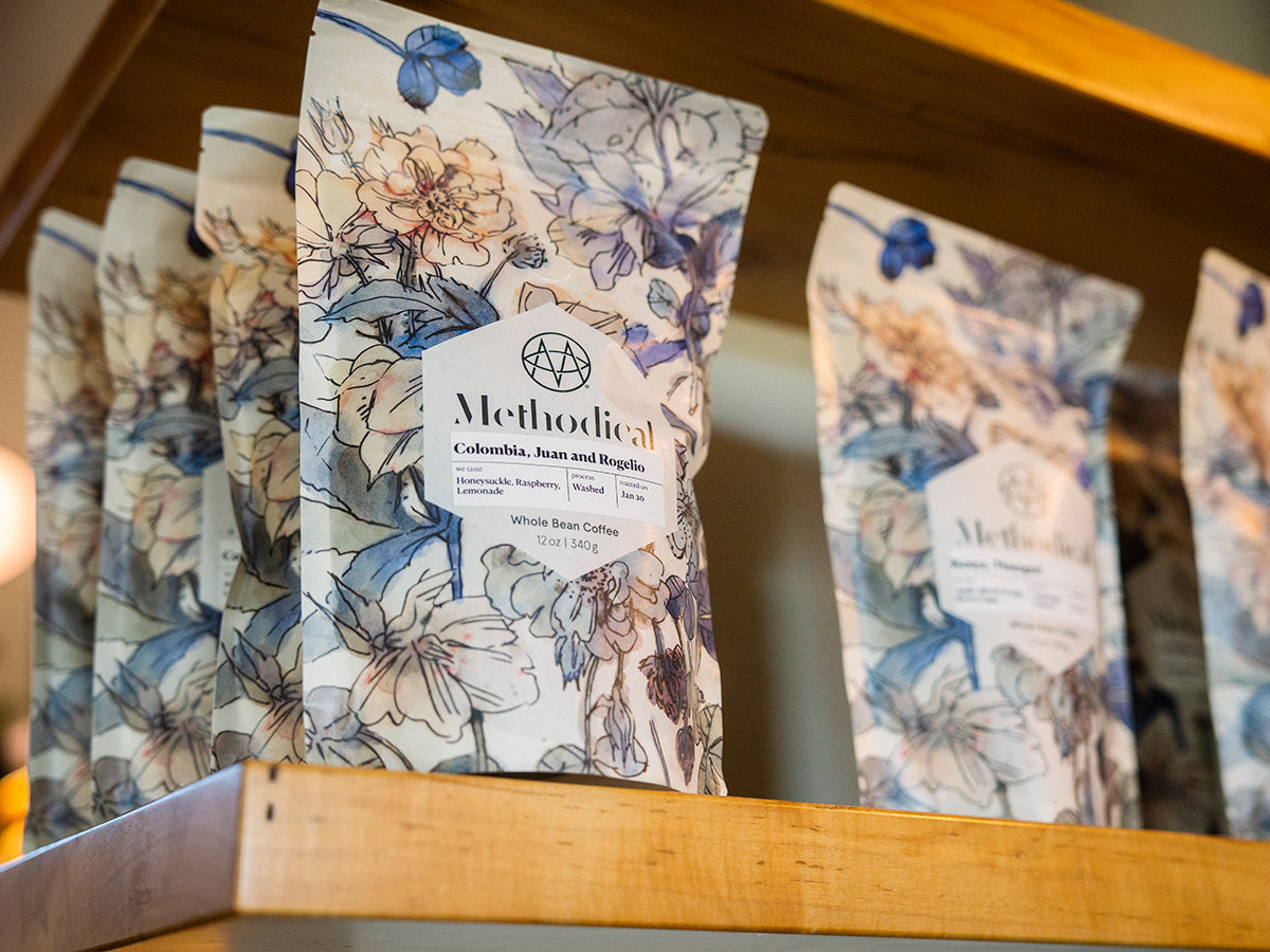 A coffee shop shelf stocked with bags of Methodical coffee beans
