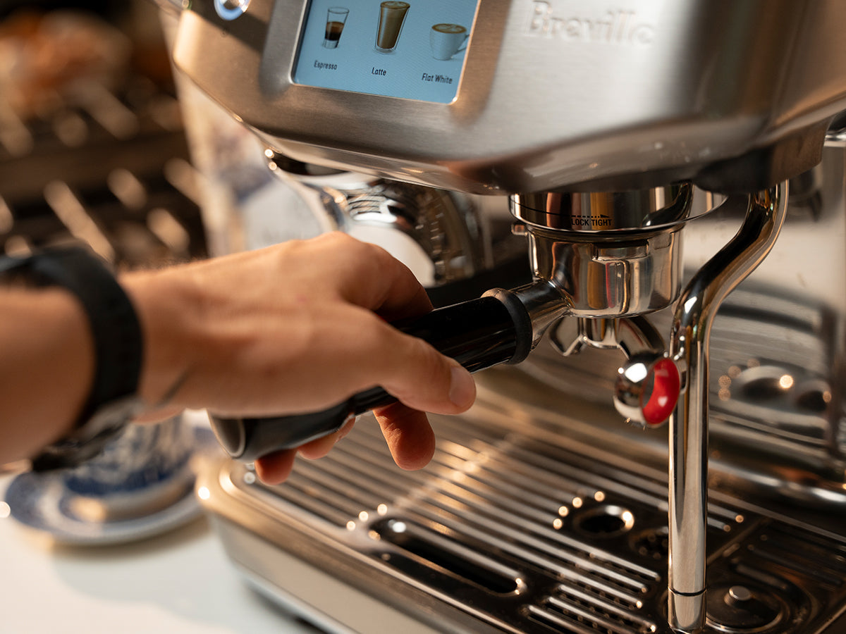 hand securing portafilter in espresso machine