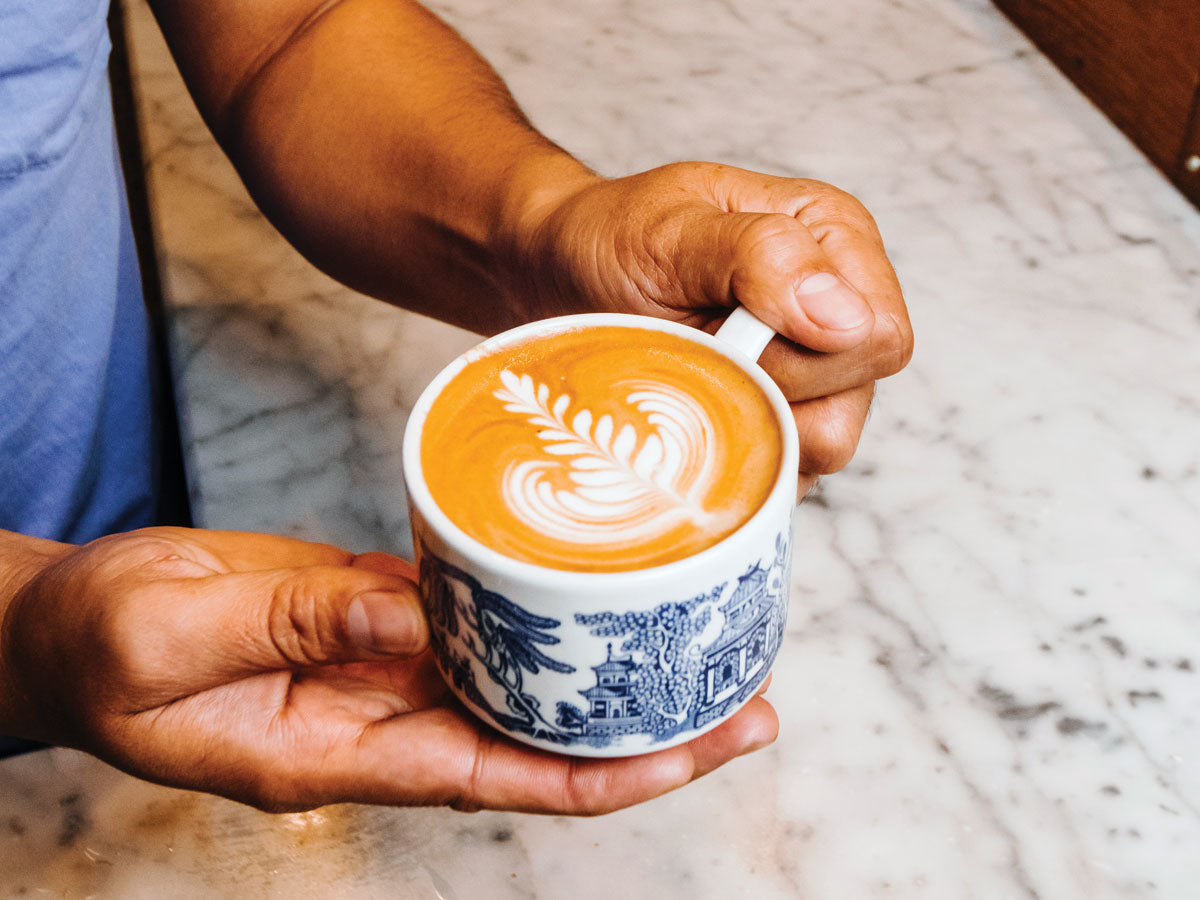 barista holding a latte
